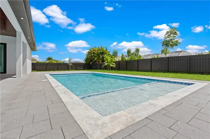 View of pool with a lawn and a patio
