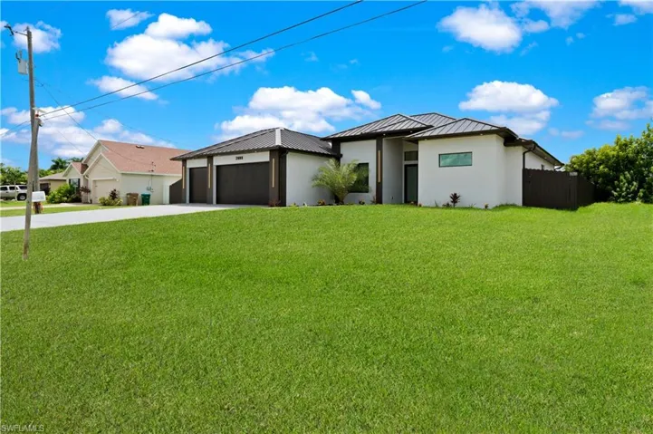 View of front of house featuring a garage and a front lawn