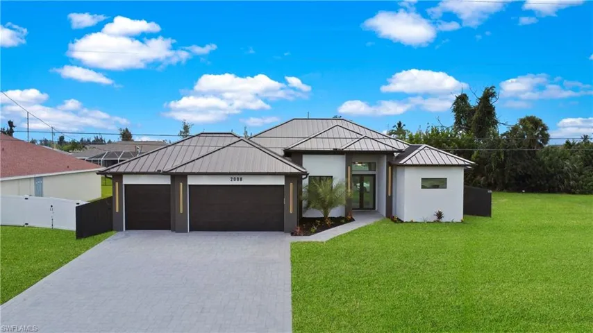 View of front of property featuring a front lawn and a garage