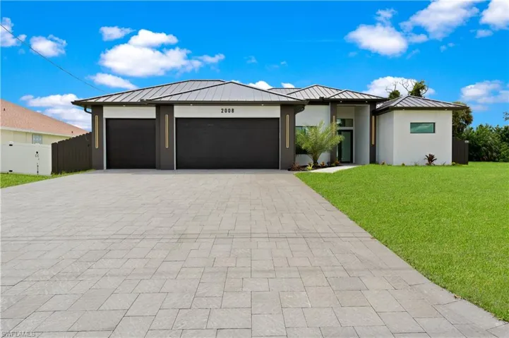 View of front of property featuring a garage and a front yard