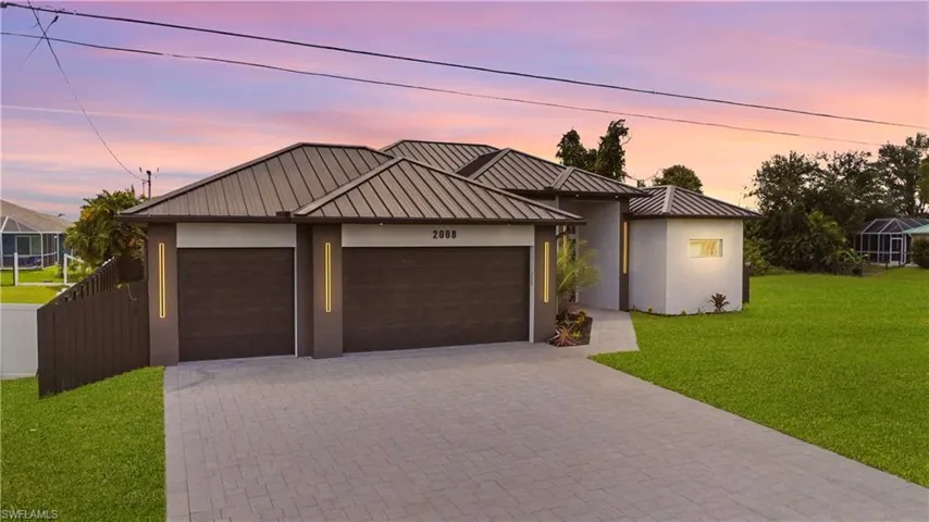 View of front facade featuring a lawn, a garage, and an outdoor structure