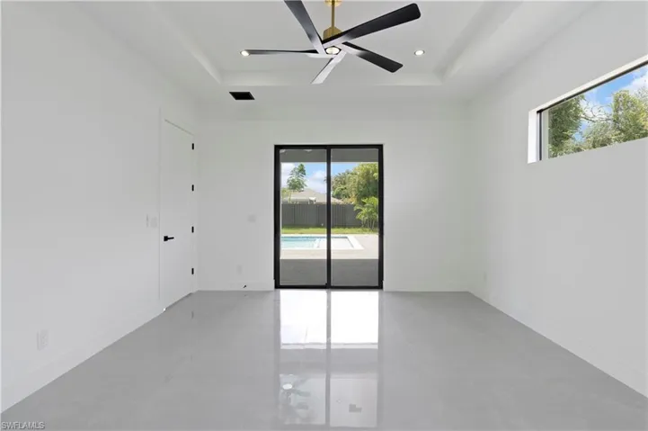Unfurnished room with a tray ceiling and ceiling fan