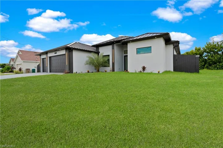 View of front of house featuring a garage and a front lawn