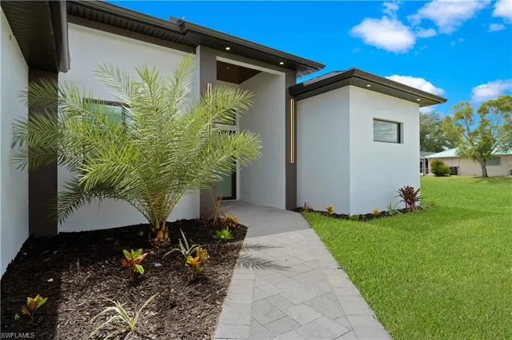 View of exterior entry featuring a yard
