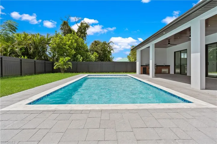 View of swimming pool with ceiling fan and a patio area