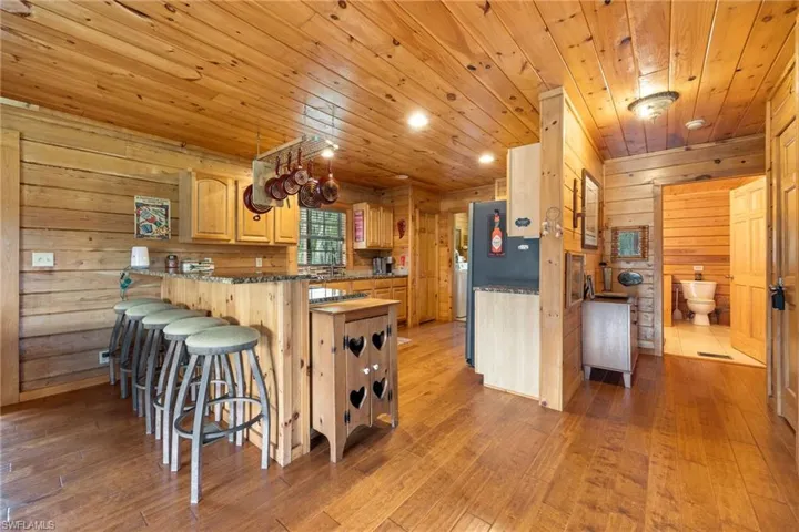 Kitchen featuring wooden walls, recessed lighting, light wood-style flooring, wood ceiling, and light wood finish cabinetry