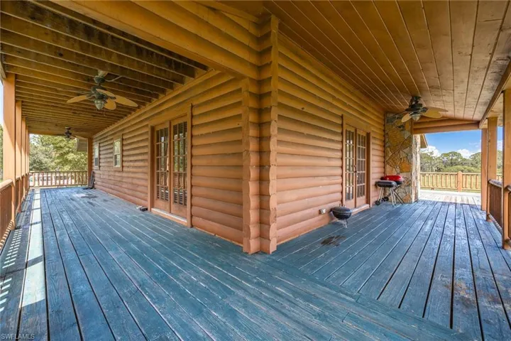 Wooden deck featuring a ceiling fan, french doors, and a grill