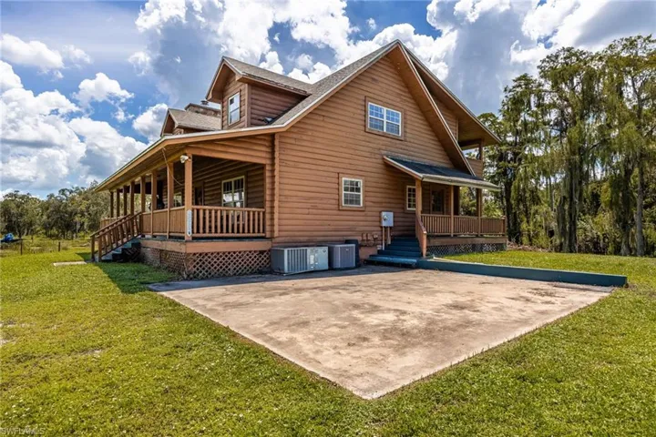 Back of property with a lawn and covered porch