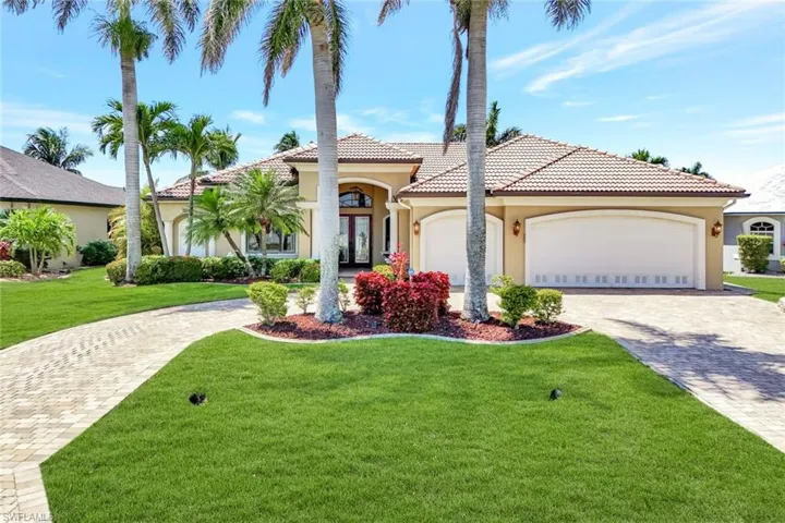 Mediterranean / spanish-style house featuring stucco siding, decorative driveway, a front lawn, and a tiled roof