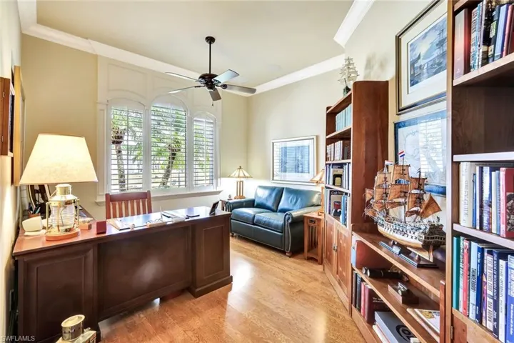 Office with ornamental molding, light wood finished floors, and ceiling fan