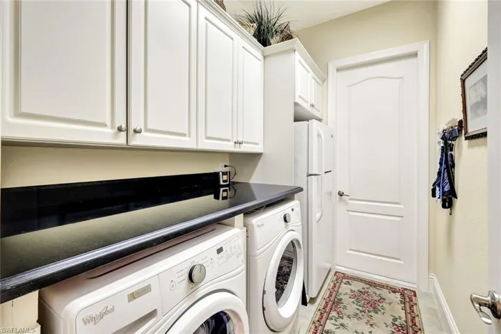 Laundry room with separate washer and dryer and cabinet space