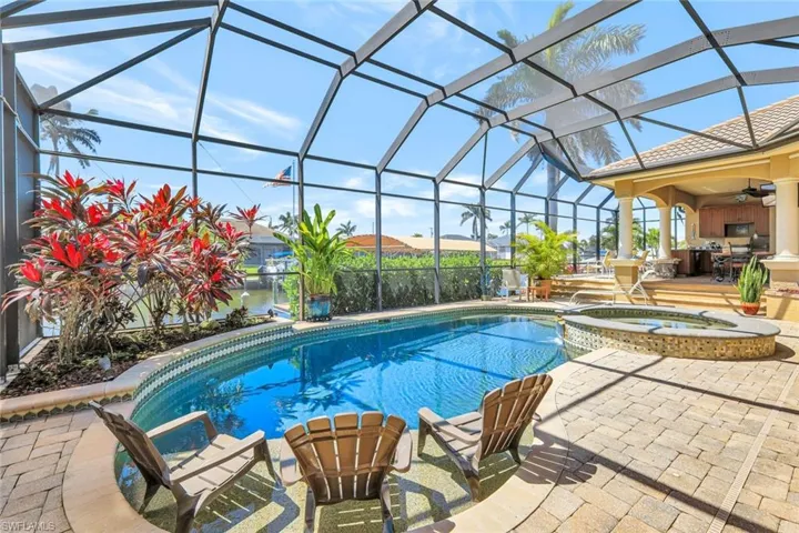 View of pool with a patio area, glass enclosure, a pool with connected hot tub, and a sunroom