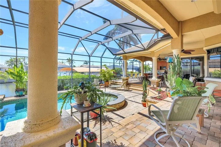 View of patio with a ceiling fan, glass enclosure, an outdoor pool, and a sunroom