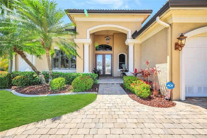 Doorway to property featuring stucco siding, french doors, and a garage