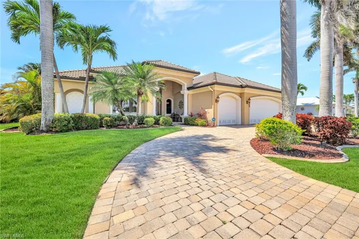 Mediterranean / spanish-style home featuring a garage, a front yard, stucco siding, and decorative driveway