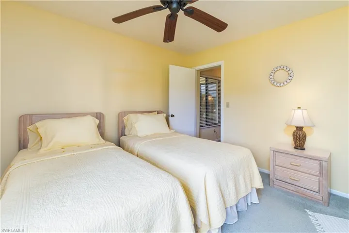 Carpeted bedroom featuring ceiling fan