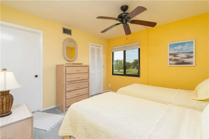 Carpeted bedroom featuring ceiling fan, a closet, and a textured ceiling