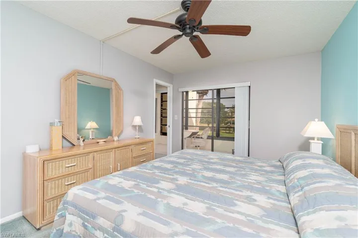 Carpeted bedroom featuring a closet, a textured ceiling, and ceiling fan
