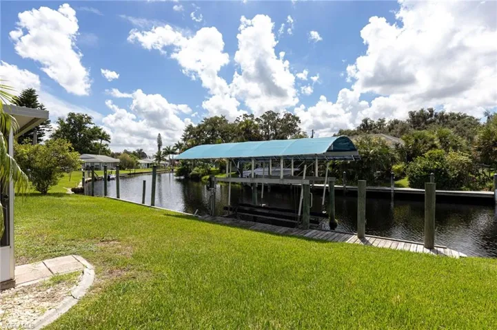 Dock with a lawn, a water view, and boat lift