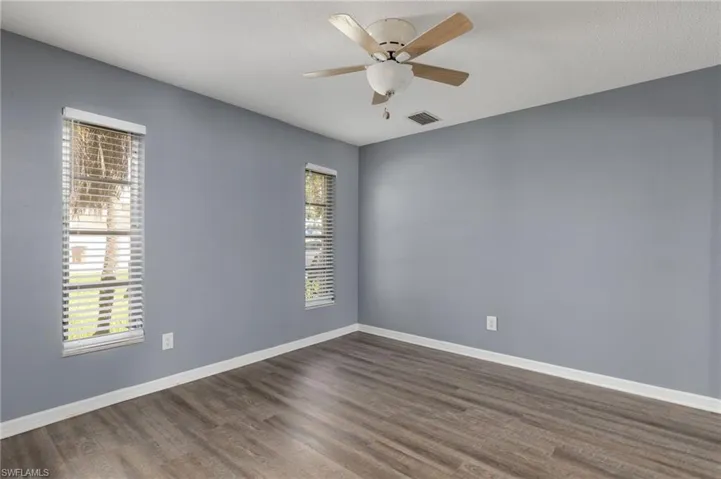 Spare room with ceiling fan and dark wood-style flooring