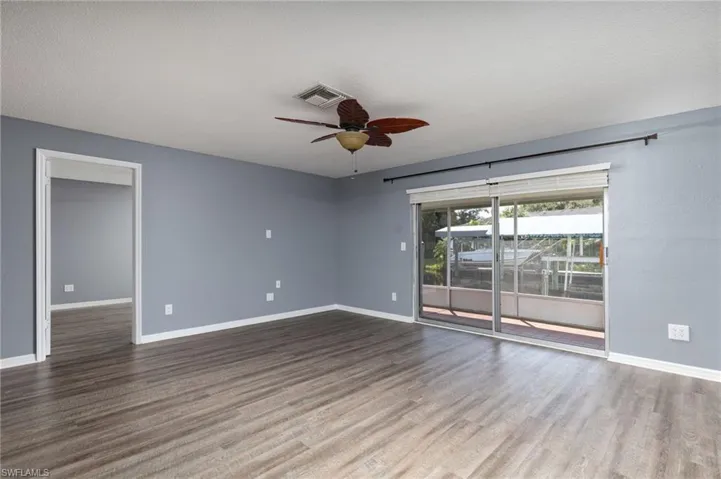 Empty room featuring a ceiling fan, wood finished floors, and a textured ceiling