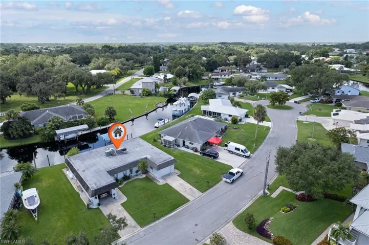 Aerial view of property and surrounding area featuring nearby suburban area