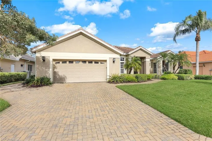 Single story home with a garage and a front lawn