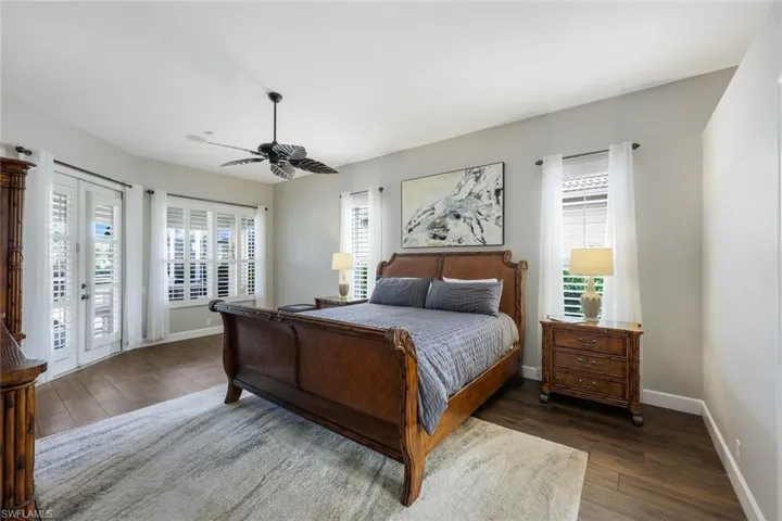 Bedroom with ceiling fan, access to exterior, dark wood-type flooring, and french doors