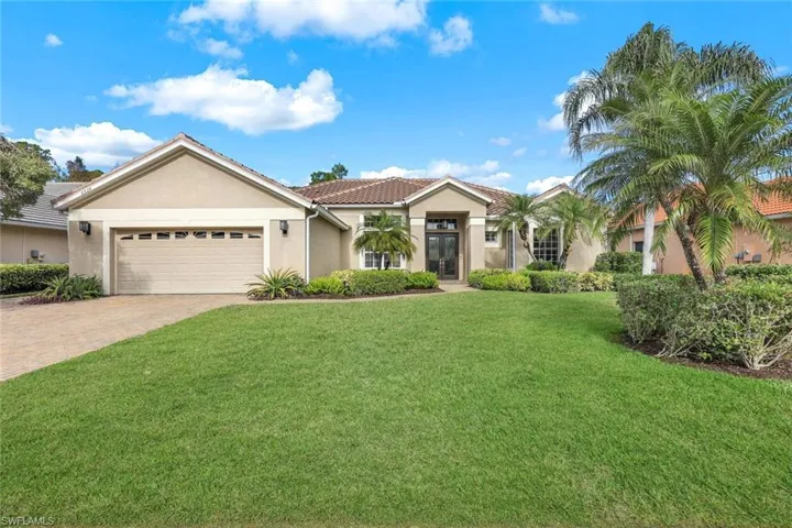 View of front of house featuring a front lawn and a garage