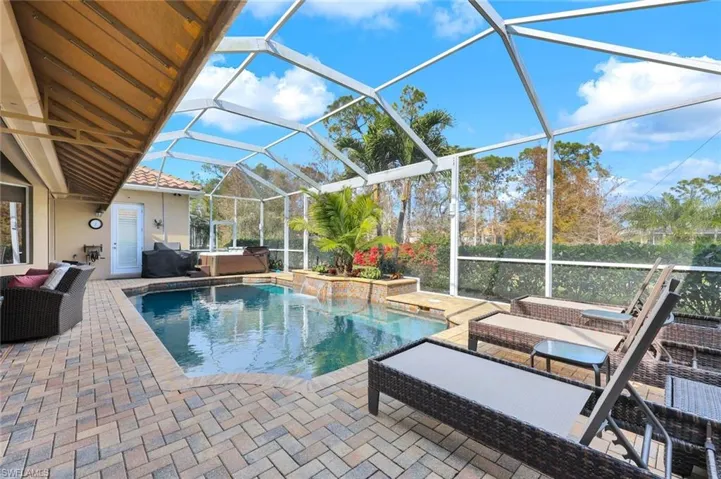 View of swimming pool with a lanai, a patio area, and a hot tub