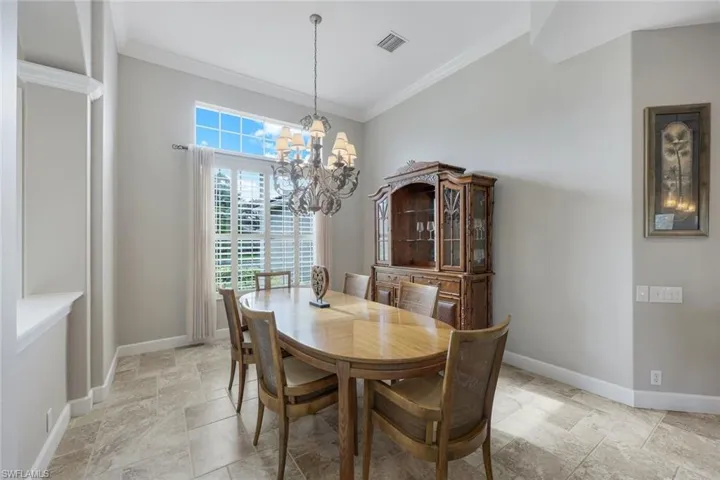 Dining space with a chandelier and crown molding