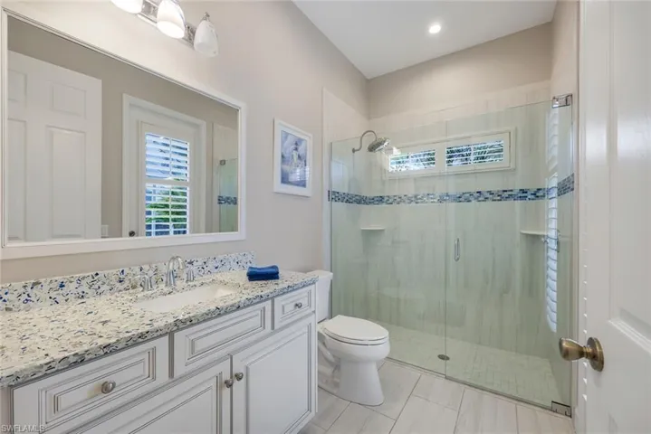 Bathroom with tile patterned floors, vanity, toilet, and walk in shower