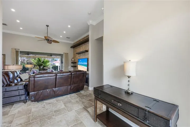 Living room featuring ceiling fan and ornamental molding