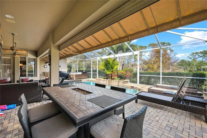 View of patio with a pool with hot tub, ceiling fan, an outdoor hangout area, and glass enclosure