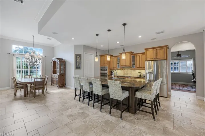 Dining space featuring ceiling fan with notable chandelier, crown molding, a healthy amount of sunlight, and sink