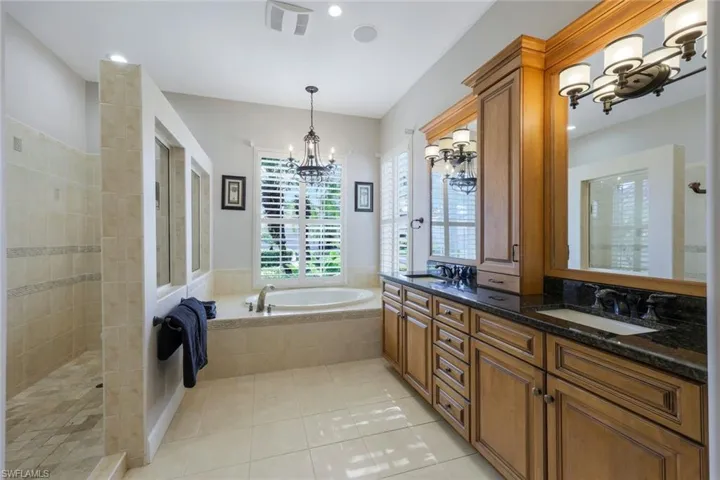 Bathroom featuring shower with separate bathtub, vanity, and tile patterned floors