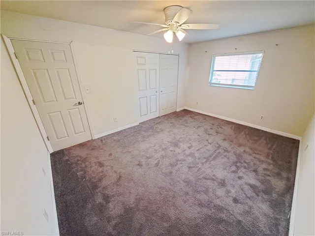 Unfurnished bedroom with carpet, a closet, and ceiling fan