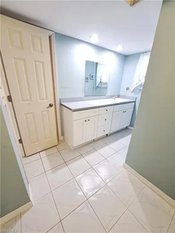 Bathroom with double vanity and light tile patterned flooring