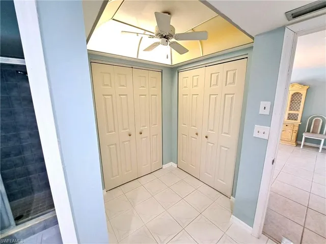 Entryway with light tile patterned floors and ceiling fan