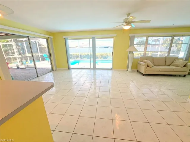Living area featuring plenty of natural light, light tile patterned floors, and ceiling fan