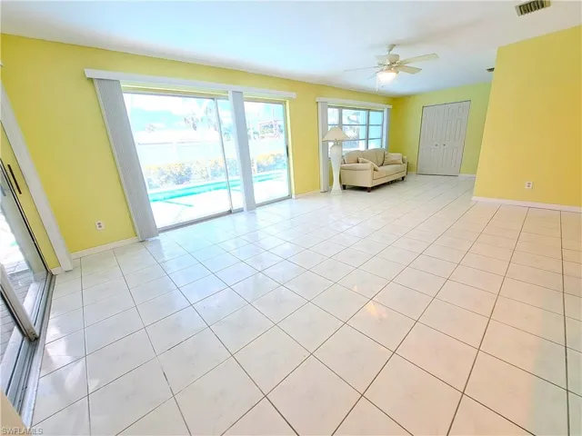 Living room with light tile patterned floors and ceiling fan