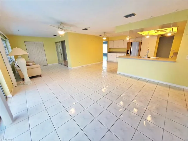Unfurnished living room with light tile patterned flooring and ceiling fan