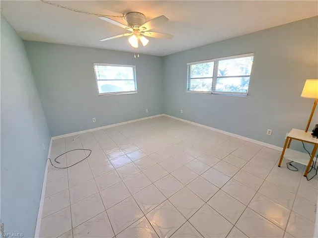 Spare room with light tile patterned floors, plenty of natural light, and a ceiling fan