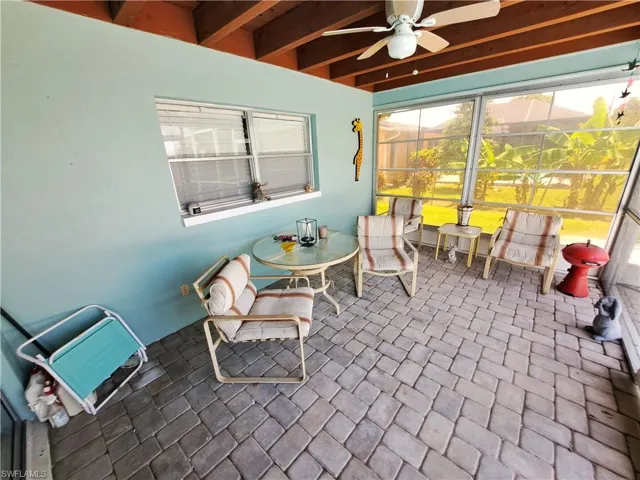 Sunroom / solarium with ceiling fan and beam ceiling