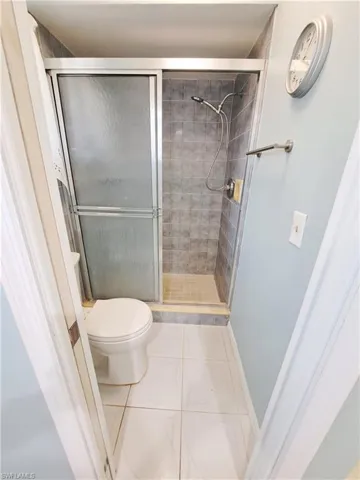 Full bathroom featuring tile patterned floors and a shower stall