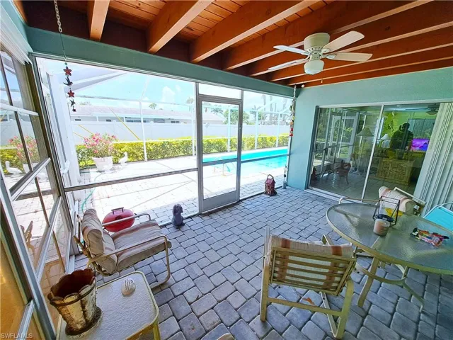 Sunroom with a ceiling fan, beamed ceiling, and plenty of natural light