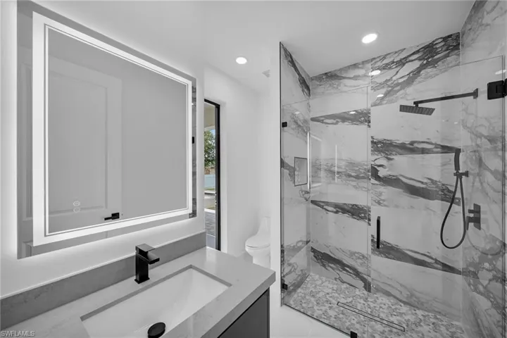 Bathroom featuring vanity, toilet, and walk in shower