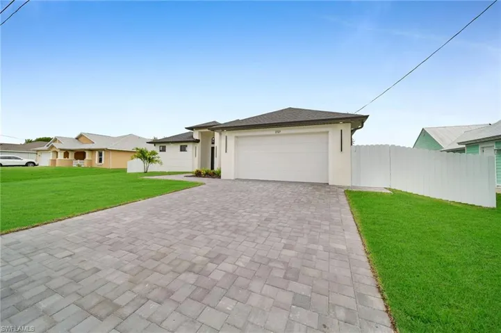 View of front of house with a garage and a front yard