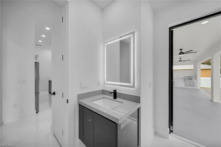 Bathroom featuring vanity, ceiling fan, and tile patterned flooring