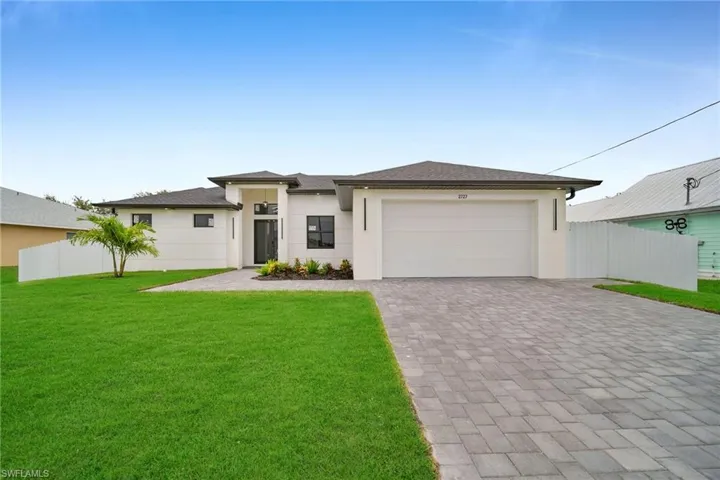 View of front of house with a garage and a front yard
